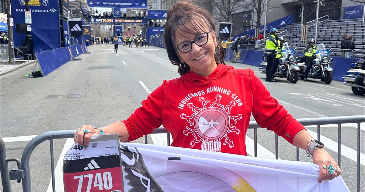Robyn Michaud stands at the edge of the Boston Marathon route ahead of her 38th marathon, and third in Boston