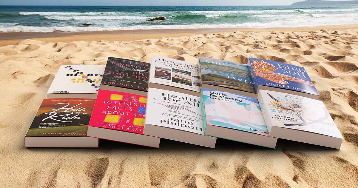 Collection of books on a beach.