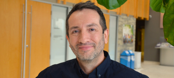 A photo of Faculty of Education associate professor Dr. Augusto Riveros, who is pictured inside the Faculty of Education Building's front lobby.