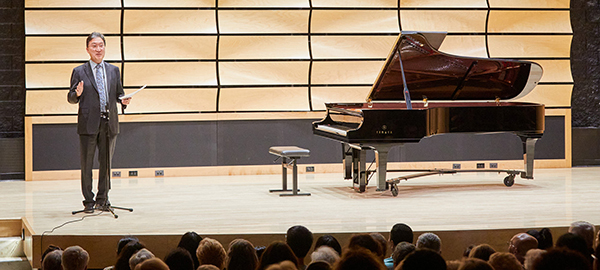 Michael Kim speaking on von Kuster Hall stage