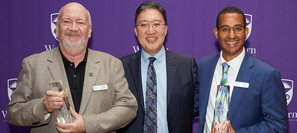 Pictured holding their awards, Wall of Fame inductees Brian McIntosh and Jamie Hillman with Dean Michael Kim