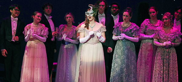 Cast of opera Die Fledermaus singing on stage in period costume