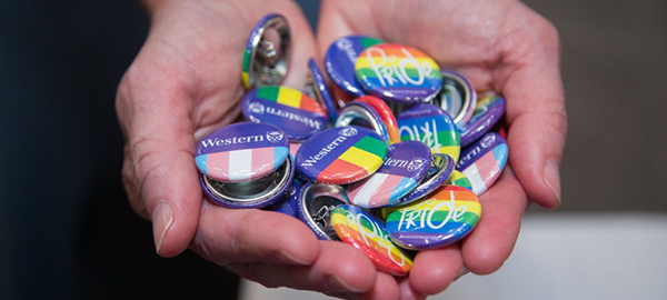 Collection of pride and transgender flag pins with Western's logo
