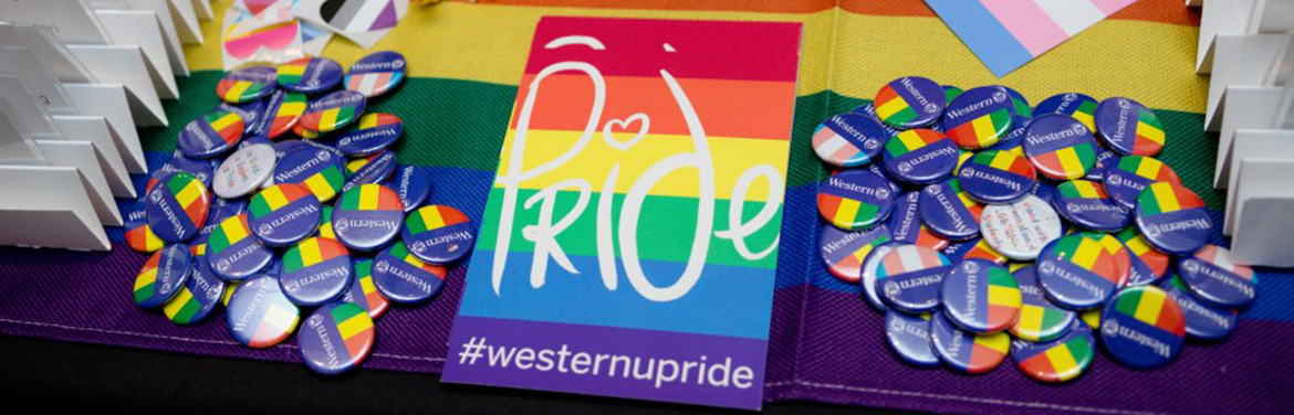 Pride flags and pins sit on a reception table with a black cloth