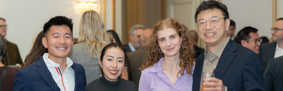 four people taking a group photo