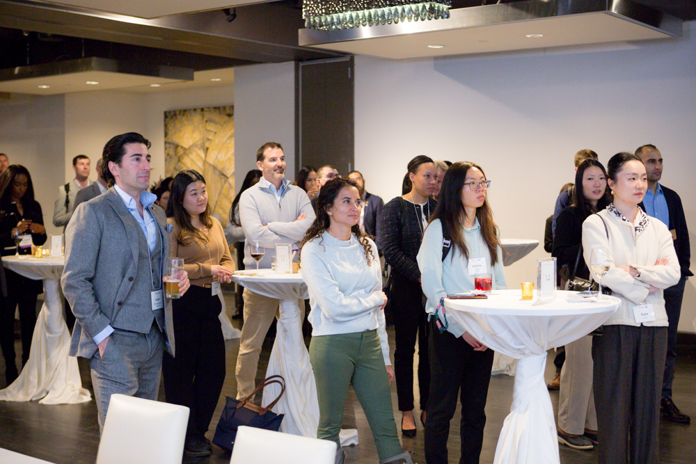 Group Of People Standing And Listening To The Speaker