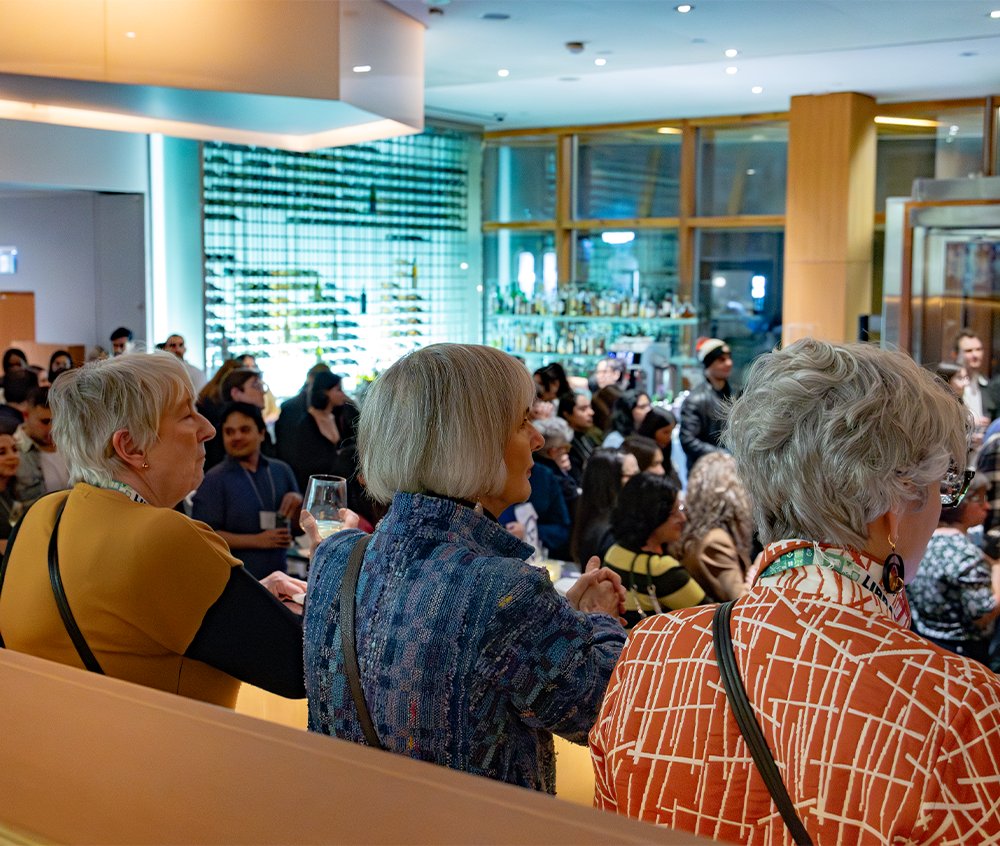 Three People Sitting Listening To Speaker